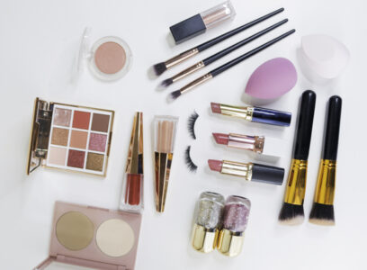 Makeup brush and decorative cosmetics on a white background.