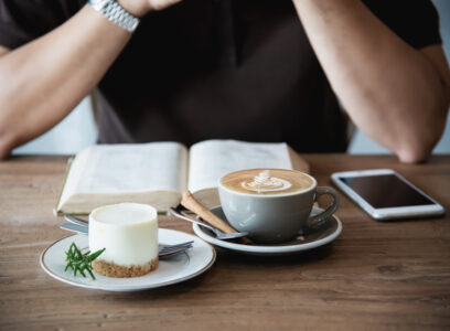 Relax Asian man drink coffee and read book in a modern style coffee shop - people with coffee cup easy lifestyle concept