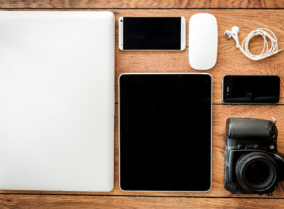 Up to date technology. Top view of diverse personal accessory laying on the wooden grain